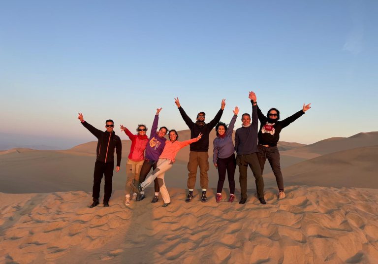 viajeros jocosos en las dunas de arena de Huacachina