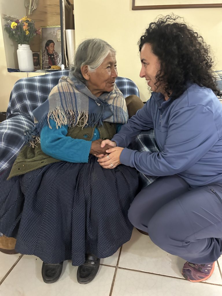 La coordinadora del viaje en grupo, compartiendo historias con una persona mayor descendiente de los incas